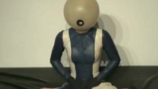 Girl Performs Breath Play With Transparent Latex Ballhood And Rubber Sheet