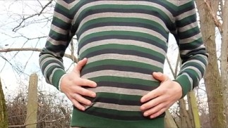 Живот красавчика растет под свитером на улице - надувание живота воздухом