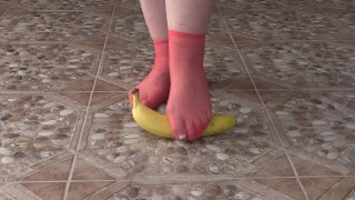 Le gambe grasse nei calzini calpestano spietatamente la banana. Crush Fetish, feticismo dei piedi.