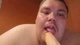Fat man sucking a dildo