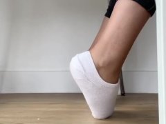Peek on tanned girl with cute feet in white socks as she works
