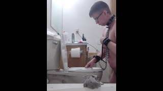 vastgeketende slaaf maakt toilet schoon