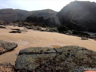 Handjob on the beach behind the rocks