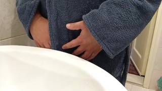 Pissing in the sink wearing a bathrobe.