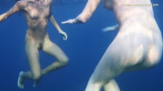 海で裸で泳ぐセクシーな女の子 2 人