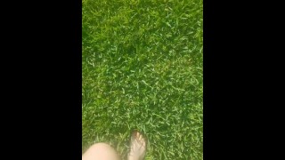 Sexy jovencita descalza camina a través de la hierba 