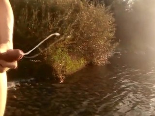 Твинк с волосатым лобком дрочит свой член, кончает на реке и его сперма плавает