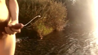 Твинк с волосатым лобком дрочит свой член, кончает на реке и его сперма плавает