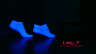 Mistress tonen mooie voeten in witte sokken in neon licht, voet aanbidding POV