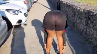 性感女孩在公共停车场穿着透明短裤弯腰