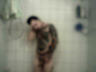 Homme bi et tattoué prend une longue douche chaude
