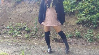 Japanischer Crossdresser pinkelt offen im Wald nach einem Selfie.