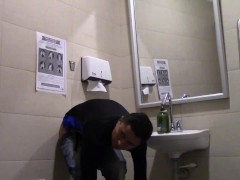 Young man enters the bathroom of a supermarket and leaves it full of milk