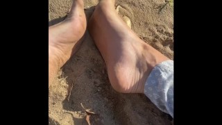 Arching my perfect feet in the sand 