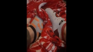 Tiny feet in mix match socks rubbing blanket