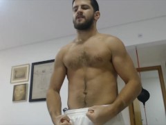Amateur stud working out at home and flexing his muscles