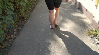 BBW em chinelos caminha pela calçada enquanto um voyeur espia em seus pés Fetiche por pés públicos