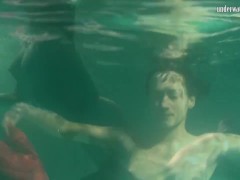 Red dressed mermaid Rusalka swimming in the pool