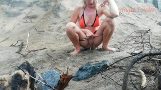 Public peeing teen girl on the beach