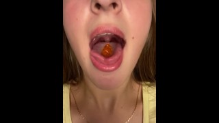 Engolindo ursinhos de goma com a boca aberta