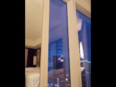 Video Elegant toy shows her body off to the city in the window of a high rise hotel.