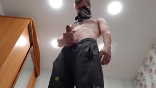 Chav lad jerks off a big cock in sweatpants and black sneakers