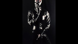 Латексное существо трахает пальцами свою силиконовую киску