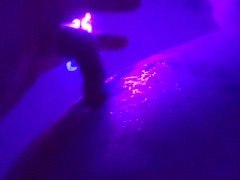 Washing her cheeks in the bath with a blacklight