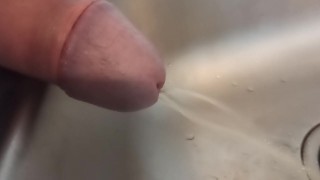 Close-up van lul tijdens het pissen in de gootsteen