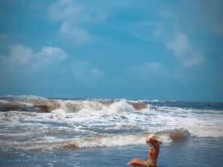 Tik Tok. Beach Voyeur looks on Blonde Teen enjoying Topless in the waves.