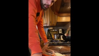 Italienischer Kerl kommt beim Kochen des Mittagessens