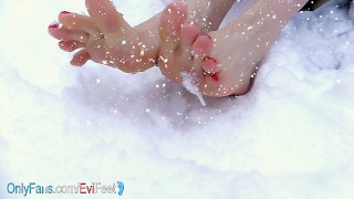 Счастливые ножки играют в снегу