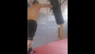 Boxen des schweren Sacks. Echter Bad Boy und heterosexueller Pornodarsteller beim Training.