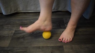 Massagem nos pés com uma bola de ouriço