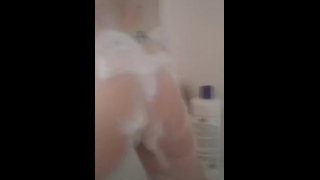 Le butin savonneux d’une jeune femme rebondit sous la douche