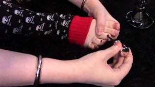 Red Vinil Kitty pinta as unhas dos pés enquanto usa aquecedores de caveira