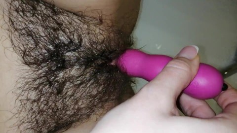 Hairy pussy plays with a vibrator and gets an orgasm in the bathroom
