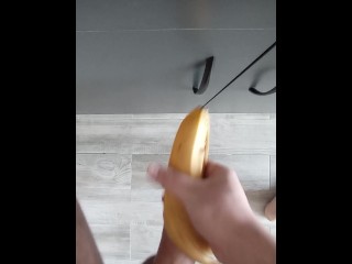 Парень соло трахает банан и кончает на пол