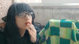 그녀는 화장을 하고 발코니에서 담배를 피운다