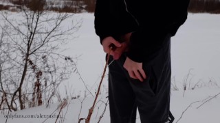 Russian guy walks in the snow near the river, pissing in the snow, he was noticed by a strange guy