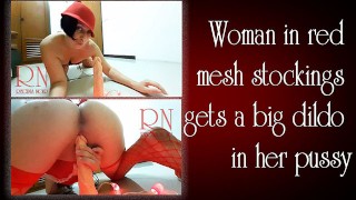 Eine Frau in roten Netzstrümpfen bekommt einen großen Dildo in ihre Muschi Regina Noir