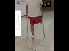 Amputee guy walking around with crutches