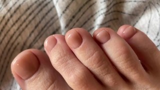 Dedos dos pés com pedicure bege