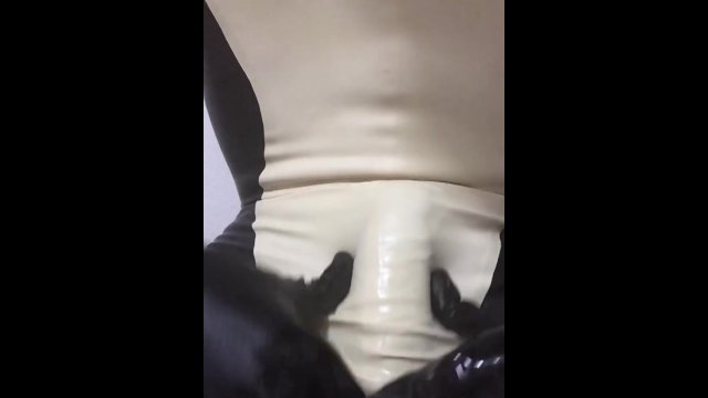 Handjob wearing latex catsuit with latex sheath inside