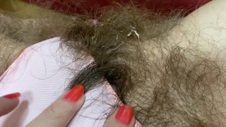 Волосатая киска девушки делает свои трусики грязными мастурбацией большого клитора