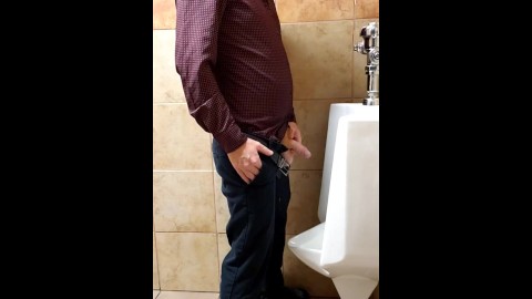 Ginger business man peeing at urinal