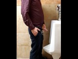 Ginger business man peeing at urinal