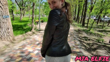 girl with big eyes walks in the park after  in a leather jacket