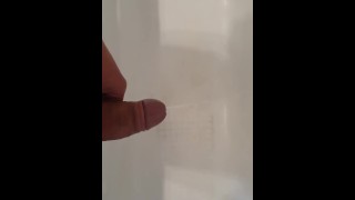 Uomo caldo che fa pipì nella vasca con un'erezione a doppio flusso