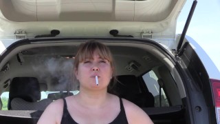 Um bbw fofo fuma na rua perto do carro